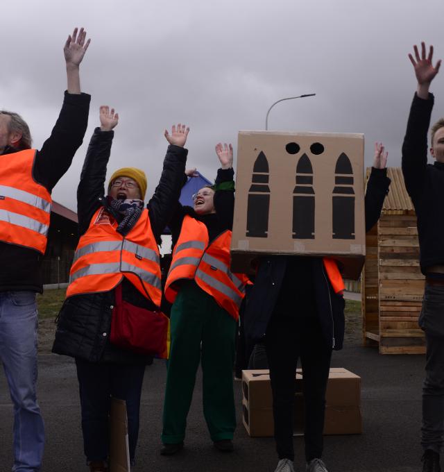 Vredesactivisten doen een mexican wave tijdens actie. 