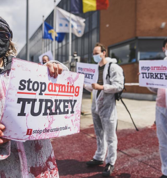 actievoerders bij wapenfabriek Sabca houden bordje "Stop Arming Turkey" vast